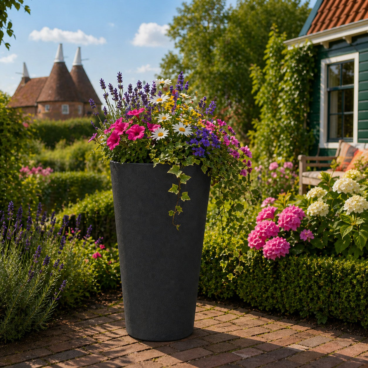 Hortus Lite - Aged Effect Tall Plastic Planter - Charcoal Black - Dia45 x H76 lifestyle - fibreglass stone-effect planter with lush greenery on modern garden terrace