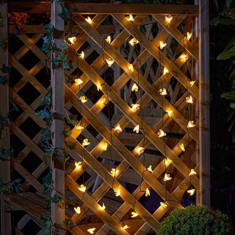 Buzzy Bee String Lights - Set of 50 lifestyle - planter with plants on garden setting