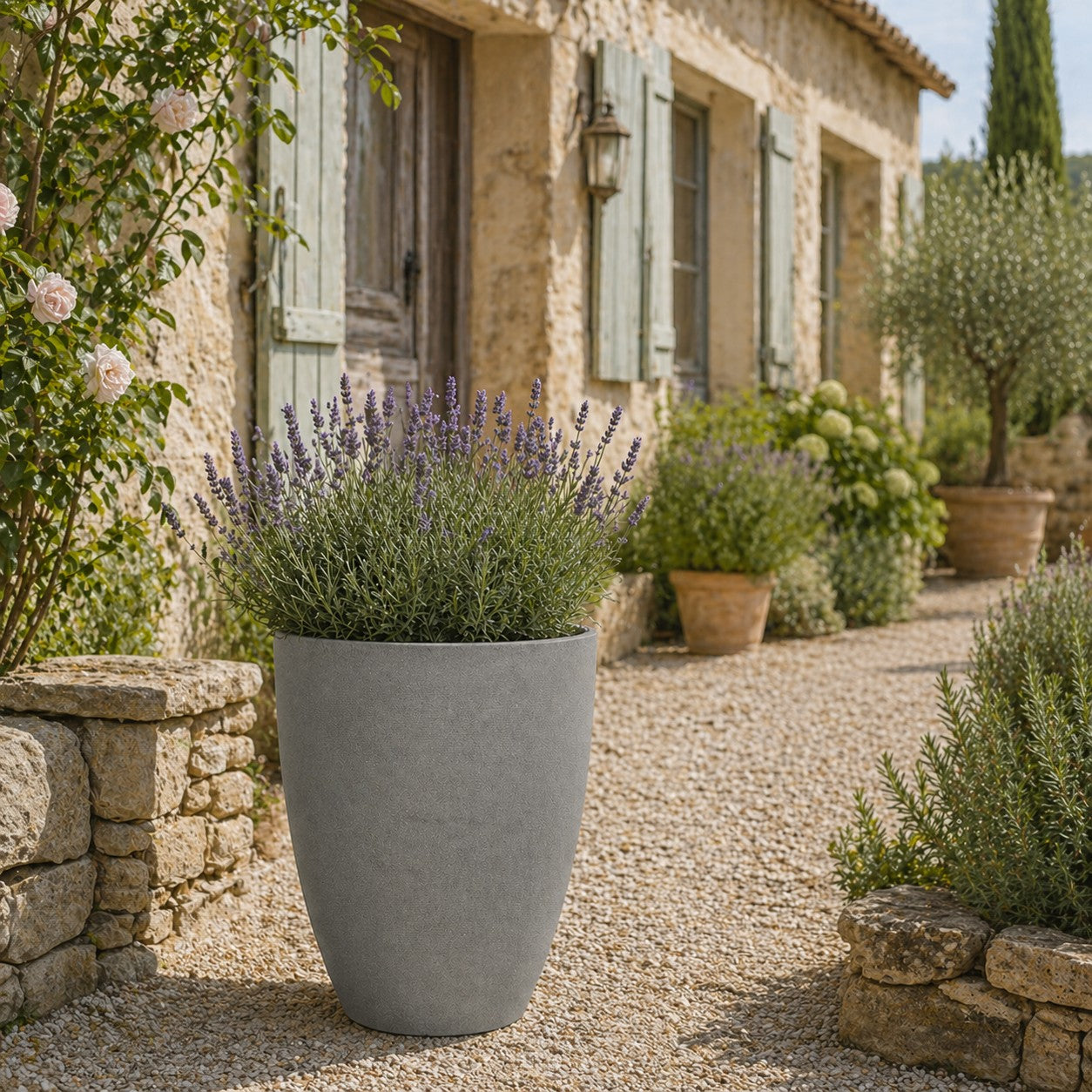 Hortus Lite - Aged Effect Plastic Mid Planter - Cement Grey - Dia 43 x Height 52.5cm lifestyle - concrete planter with lush greenery on modern garden terrace