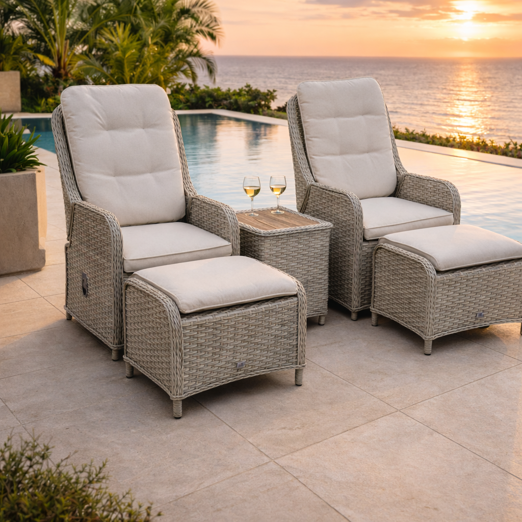 Outdoor patio furniture set with chairs, ottoman, and table by a pool with sunset view.